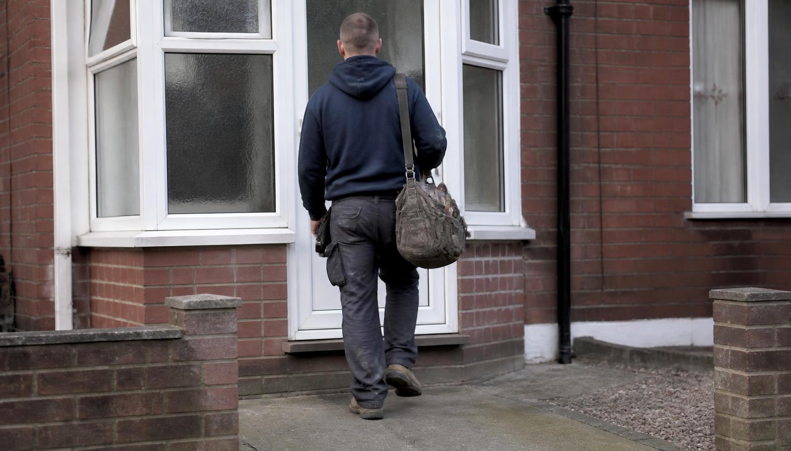 Plumber arriving at the front door of a Harpenden home with his toolbag