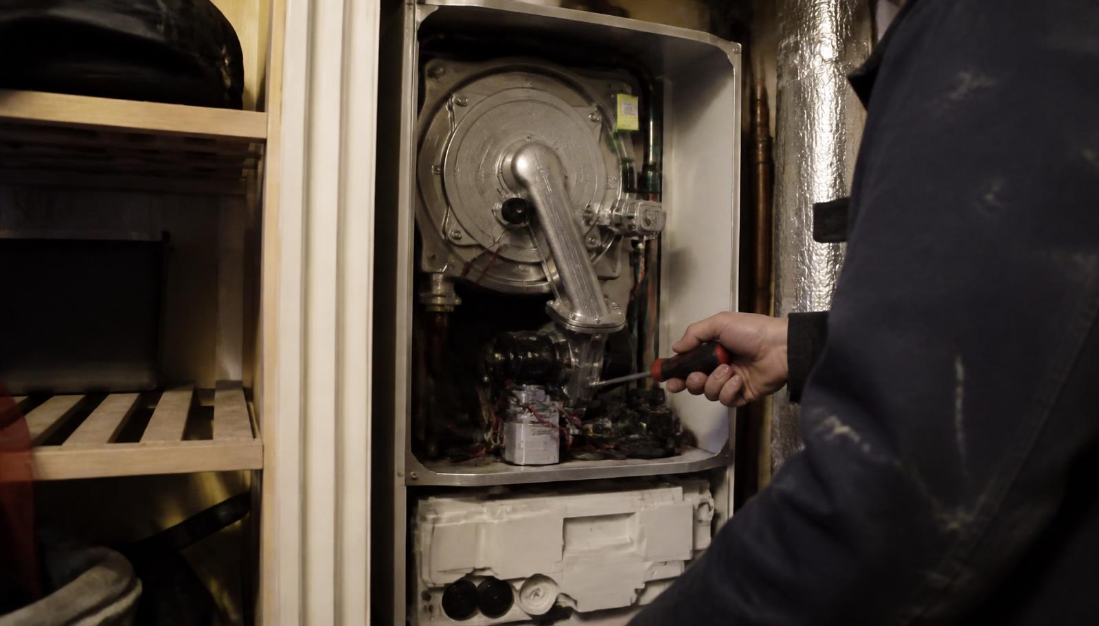 Heating engineer servicing a domestic boiler in a Hertfordshire home